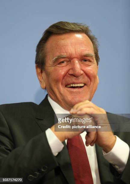 Former German Chancellor Gerhard Schroeder smiles during a presentation of his new biography with his successor, current chancellor Angela Merkel ,...