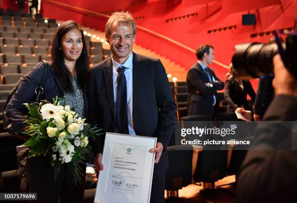 Former national soccer coach Juergen Klinsmann and his wife Debbie posing after being awarded as Honourary Team Captain of the German National Soccer...