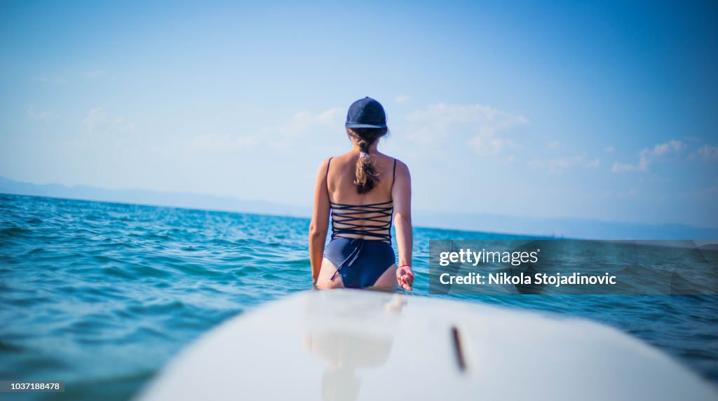 Eine Frau zieht ein Surfbrett
