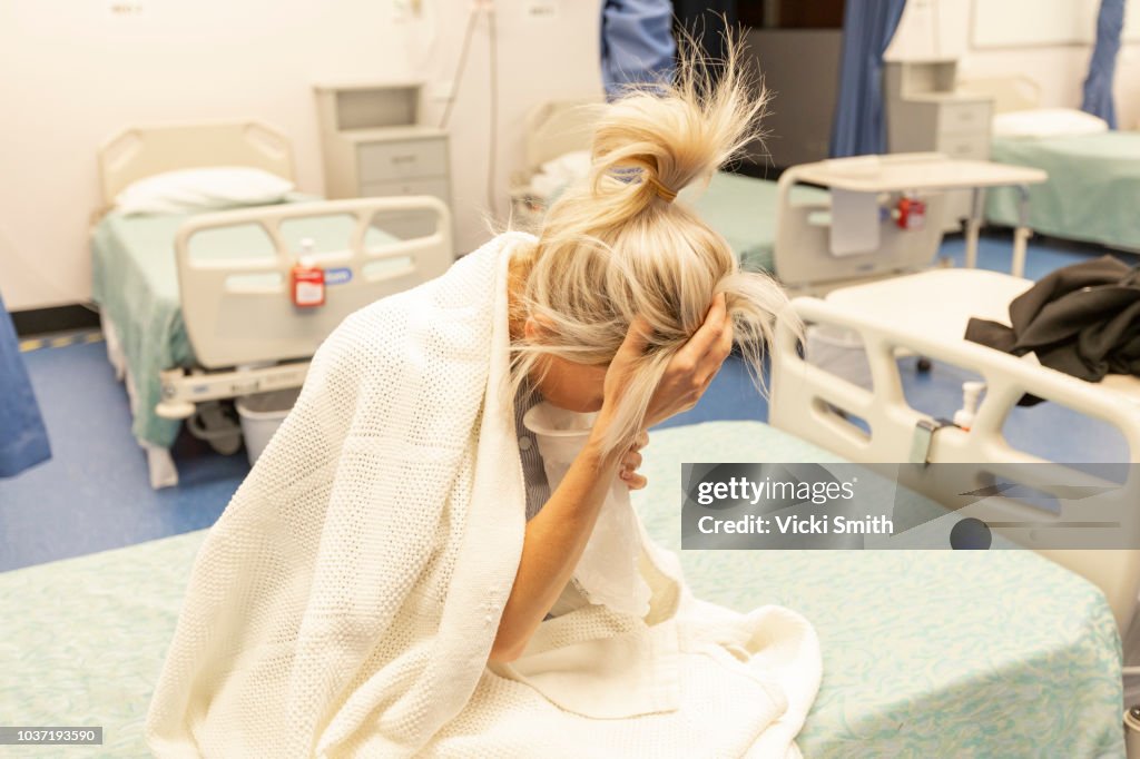 Woman on hospital bed feeling sick