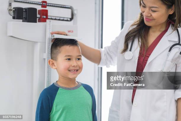 young boy at the doctor's office - mass unit of measurement stock pictures, royalty-free photos & images
