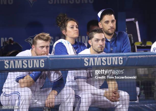 Justin Smoak of the Toronto Blue Jays and head athletic trainer Nikki Huffman and Randal Grichuk and Marco Estrada look on from the top step of the...