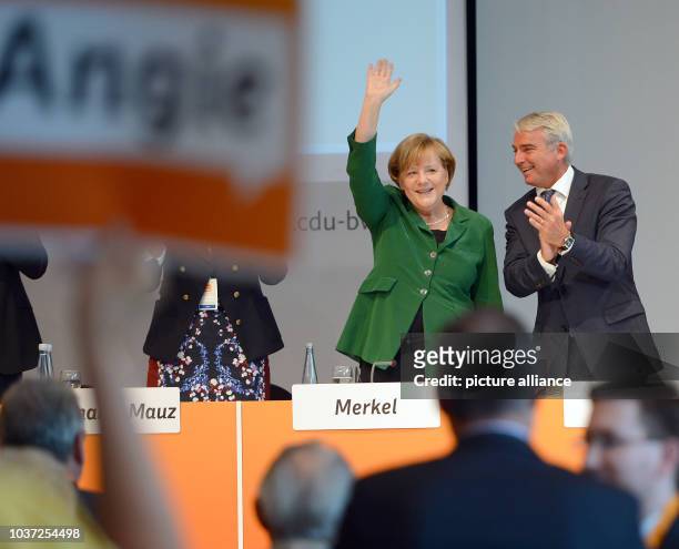 German Chancellor Angela Merkel and CDU chairman for Baden-Wuerttemberg Thomas Strobl wave at an election campaign event for the 2013 German federal...