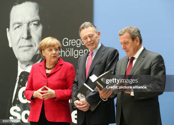 German Chancellor Angela Merkel , her predecessor Gerhard Schroeder and writer Gregor Schoellgen talk during the presentation of Schroeder's new...