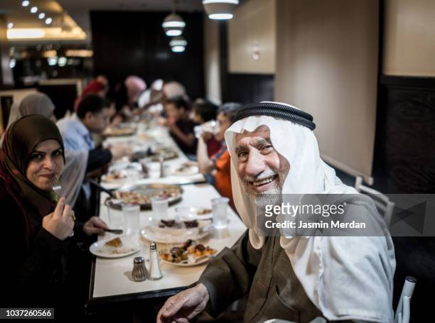 muslim family together in restaurant - イフタール ストックフォトと画像