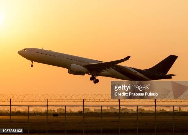 passenger airplane landing on runway in airport. evening - plane taking off stock pictures, royalty-free photos & images