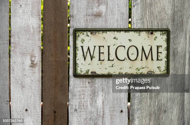 blackboards with inscription "welcome" on wooden background - sinal de boas vindas - fotografias e filmes do acervo