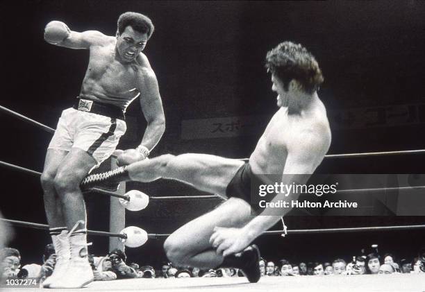 Muhammad Ali fends off a kick from wrestler Antonio Inoki during an exhibition fight in Tokyo, Japan. \ Mandatory Credit: Allsport Hulton/Archive