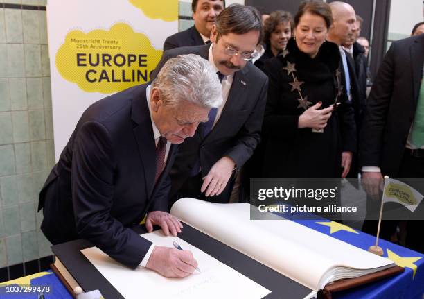 German Federal President Joachim Gauck signs a guest book in the presence of the commissary of the King for the province of Limburg, Theodorus...