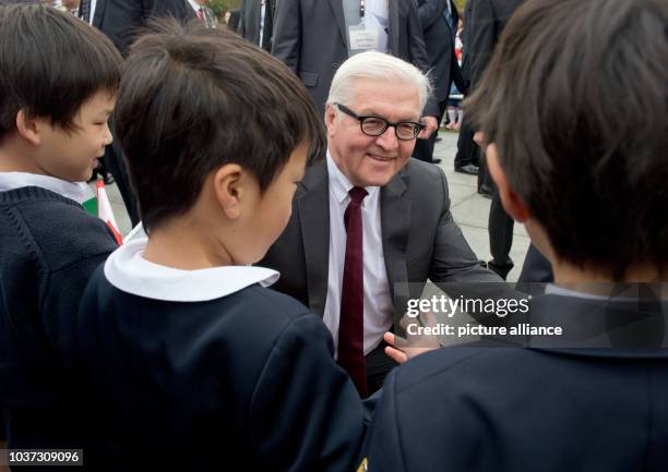 German Foreign Minister Frank-Walter Steinmeier talks to Japanese children next to the cenotaph of the memorial for the victims of the atomic bombing...