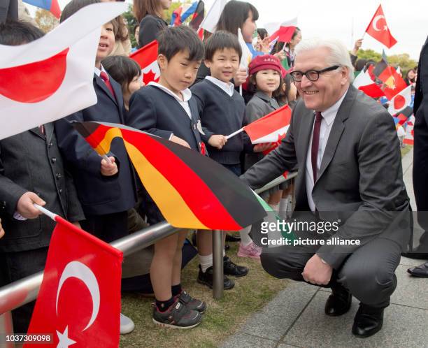 German Foreign Minister Frank-Walter Steinmeier talks to Japanese children next to the cenotaph of the memorial for the victims of the atomic bombing...