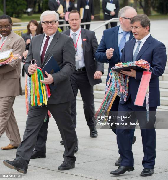 German Foreign Minister Frank-Walter Steinmeier , Dutch Foreign Minister Frans Timmermans and Turkish Foreign Minister Ahmed Davutoglu hold garlands...