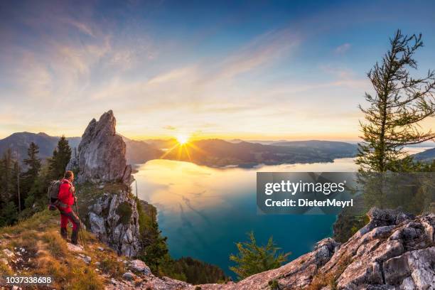 mountain climber at sunset with view to lake attersee from schober- sunset at mount schoberstein, alps - upper austria stock pictures, royalty-free photos & images