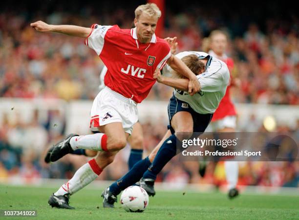 Dennis Bergkamp of Arsenal holds off John Scales of Tottenham Hotspur during an FA Carling Premiership match at Highbury on August 30, 1997 in...