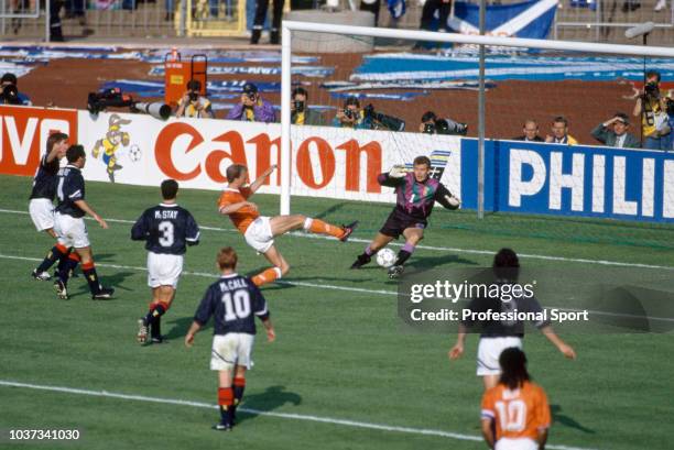 Dennis Bergkamp of the Netherlands scores past Scotland goalkeeper Andy Goram during the UEFA Euro 92 Group 2 match between the Netherlands and...