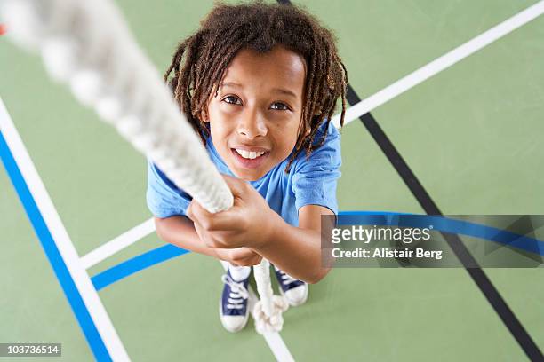 boy holding rope in gymnasium - climbing rope stock-fotos und bilder