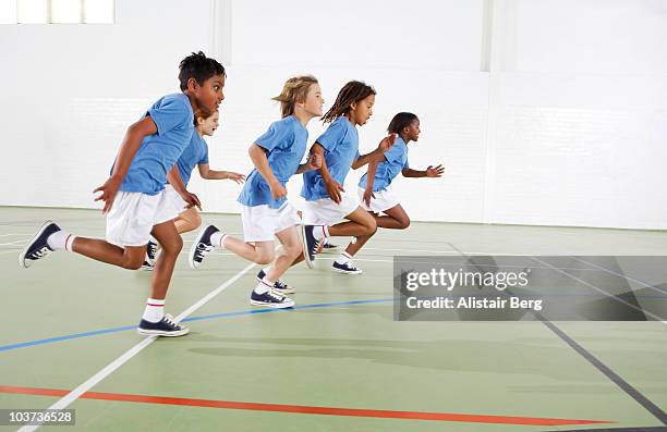 children running in gymnasium - running side view stock pictures, royalty-free photos & images