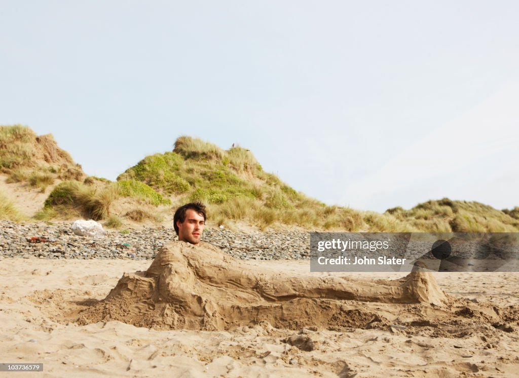 Man buried in sand at beach