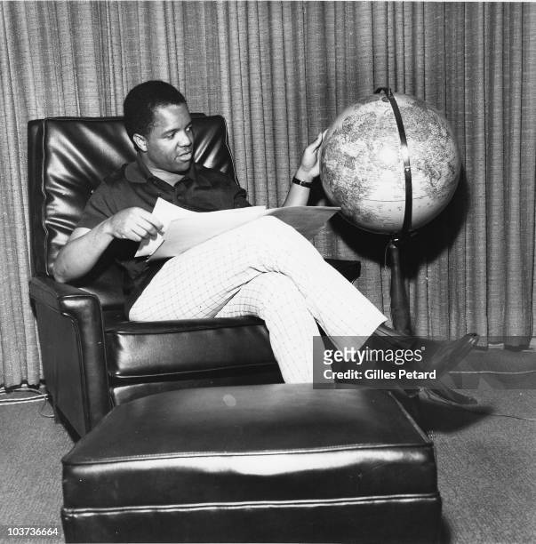 Berry Gordy Jr of Motown Records poses in his office looking at a globe in 1966 in Detroit, United States.