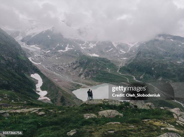 Aerial view of woman and man near the  lake in Swiss alps