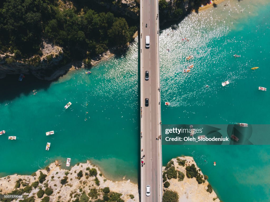 Scenic aerial view of boats on Verdon lake and cars on the bridge