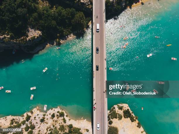 scenic aerial view of boats on  verdon lake and cars on the bridge - kayaking beach stock pictures, royalty-free photos & images