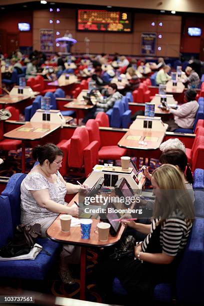 Customers play on electronic bingo screens at a Gala Bingo club, operated by Gala Coral Group Ltd., in London, U.K., on Thursday, Aug. 26, 2010. Gala...