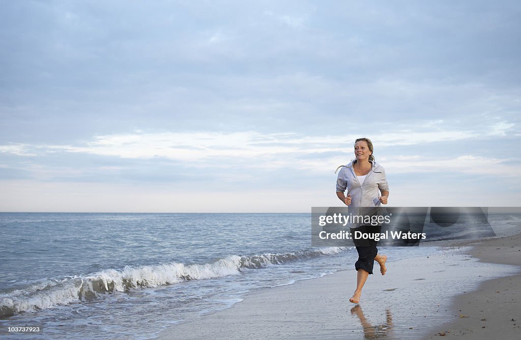 Woman running along beach.