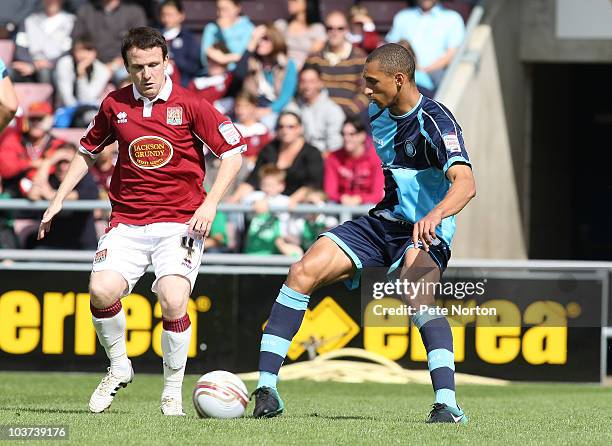 Lewis Montrose of Wycombe Wanderers looks to play the ball watched by Kevin Thornton of Northampton Town during the npower LeagueTwo match between...