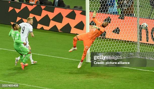 Germany's Andre Schuerrle scores 1-0 goal against goalkeeper Rais Mbolhi of Algeria during the FIFA World Cup 2014 round of 16 soccer match between...