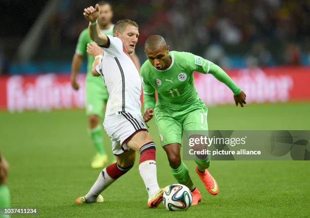 Germany's Bastian Schweinsteiger and Algeria's Yacine Brahimi vie for the ball during the FIFA World Cup 2014 round of 16 soccer match between...