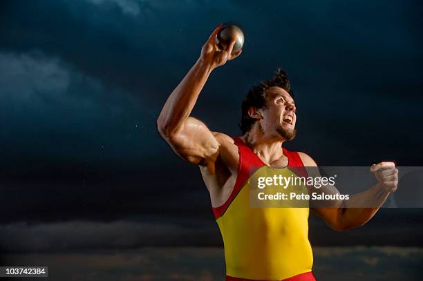 joven atleta caucásico, de sexo masculino tirando peso - lanzamiento de pesos fotografías e imágenes de stock
