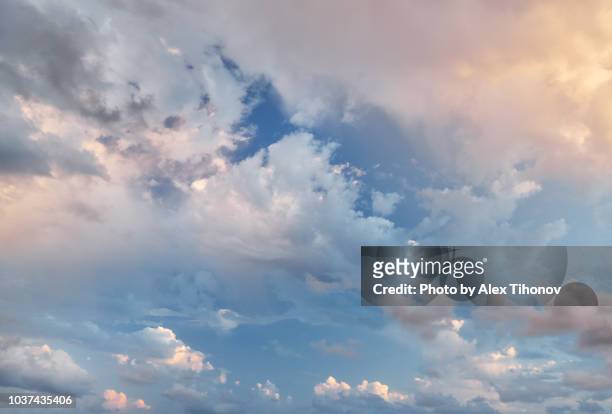 blue sky with fluffy clouds - grey sky stock-fotos und bilder