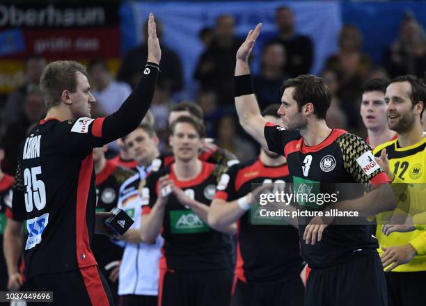 Germany's Julius Kuehn and Uwe Gensheimer high-five at the end of the men's Handball World Cup match between Belarus and Germany in Rouen, France, 18...