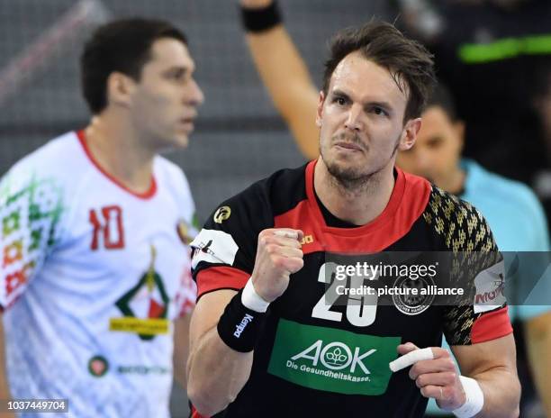 Germany's Kai Haefner gestures next to Belarus's Barys Pukhouski during the men's Handball World Cup match between Belarus and Germany in...
