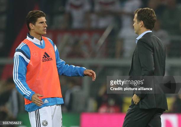Germany's Manager Oliver Bierhoff walks past replacement Mario Gomez during the UEFA EURO 2016 qualifying group D soccer match between Germany and...