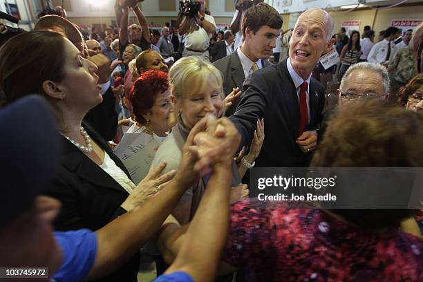 Rick Scott, the Republican candidate for governor of Florida, and his wife, Ann Scott, are greeted by supporters as he campaigns at the Sweetwater...