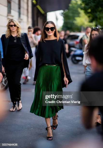 Olivia Palermo wearing green skirt, black cape, heeled sandals seen outside Etro during Milan Fashion Week Spring/Summer 2019 on September 21, 2018...