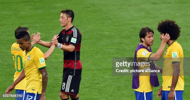 Germany's Mesut Oezil shakes hands with Brazil's Bernard after the FIFA World Cup 2014 semi-final soccer match between Brazil and Germany at Estadio...