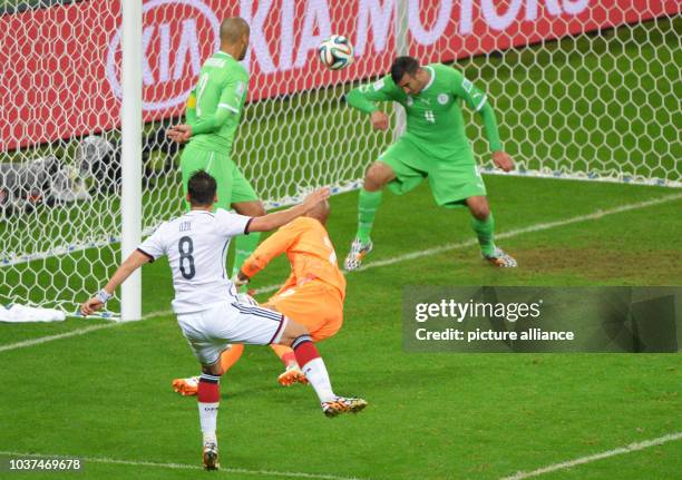 Germany's Mesut Oezil scores the 2-0 against Algeria's goalkeeper Rais Mbolhi during the FIFA World Cup 2014 round of 16 soccer match between Germany...