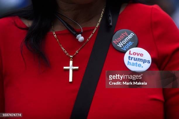 Woman wear pins that read "Nasty Women Vote" and "Love trumps hate" during a campaign rally with former President Barack Obama, Pennsylvania Governor...