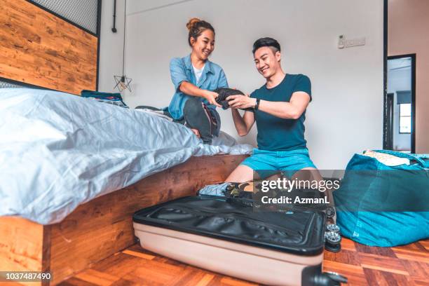 young couple packing suitcase in bedroom - suitcase couple stock pictures, royalty-free photos & images