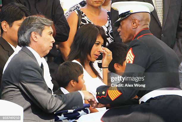 Sgt. Maj. Eric Stockton presents Francisco Rodriguez with a flag during the funeral for his son, U.S. Marine Sgt. Ronald A. Rodriguez, as his son's...