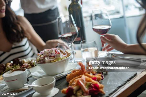 frauen im restaurant - griechischer salat stock-fotos und bilder