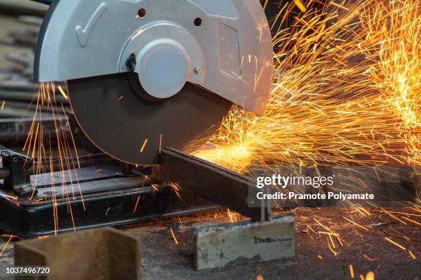 worker cutting metal with grinder. sparks while grinding iron - serra-circular imagens e fotografias de stock