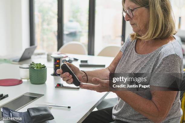 senior woman checking blood sugar levels - diabetes stock pictures, royalty-free photos & images