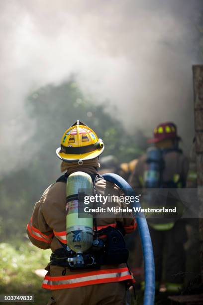 firefighters working together to contain fire - roupa a prova de fogo - fotografias e filmes do acervo