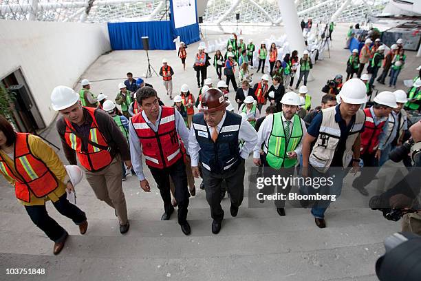 Mexican billionaire Carlos Slim, center, in red hard hat, walks during a tour of his Plaza Carso real estate development in Mexico City, Mexico, on...