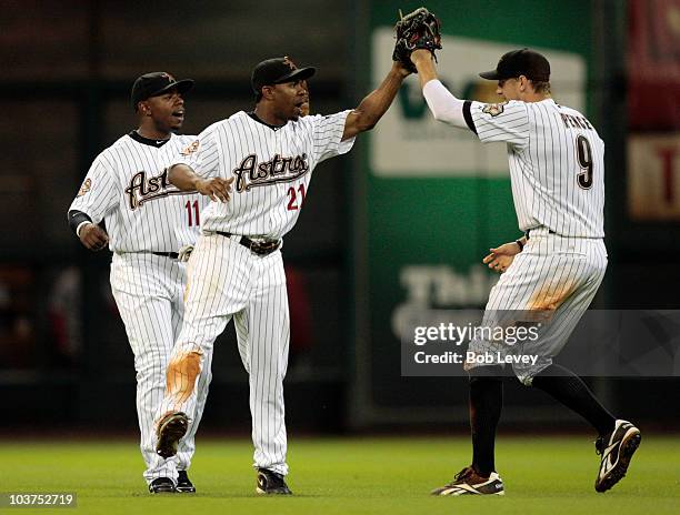 Center fielder Michael Bourn and Jason Bourgeois of the Houston Astros congratulate teammate Hunter Pence after they defeated the St. Louis Cardinals...