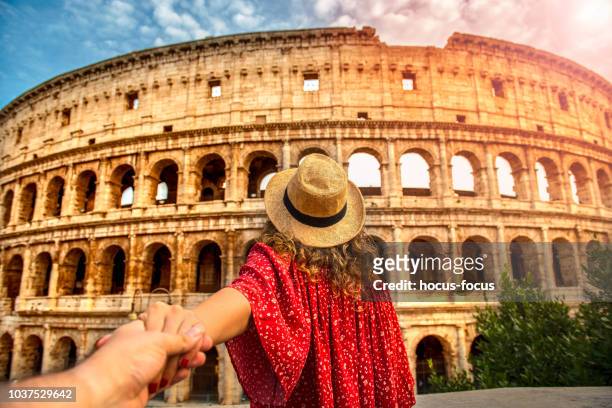 couple of tourist on vacation in front of colosseum rome italy - rome italy stock pictures, royalty-free photos & images